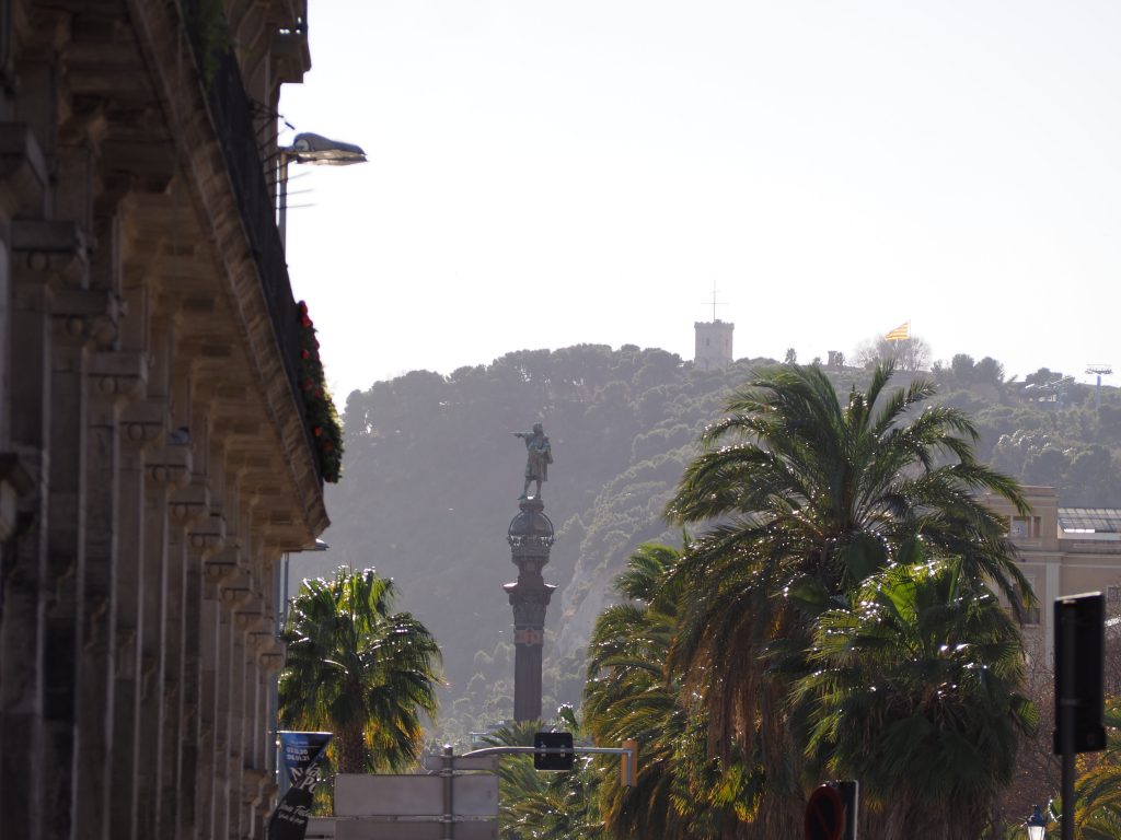 The Columbus monument in Barcelona with Montjuic hill on the background. Highlights tour.