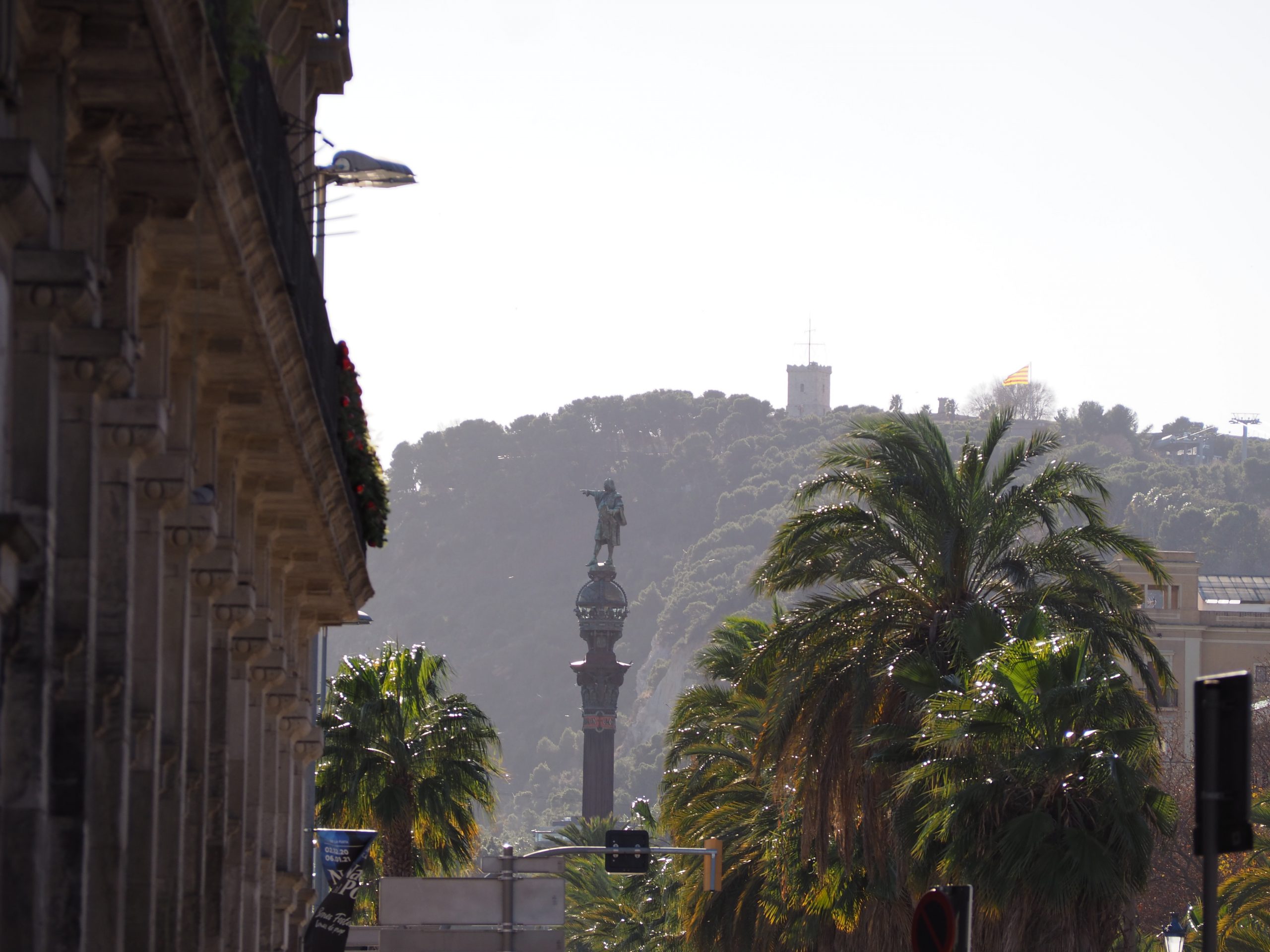 Le monument de Colomb sur la Rambla à Barcelone avec la colline de Montjuic en arrière-plan. Visite des incontournables.