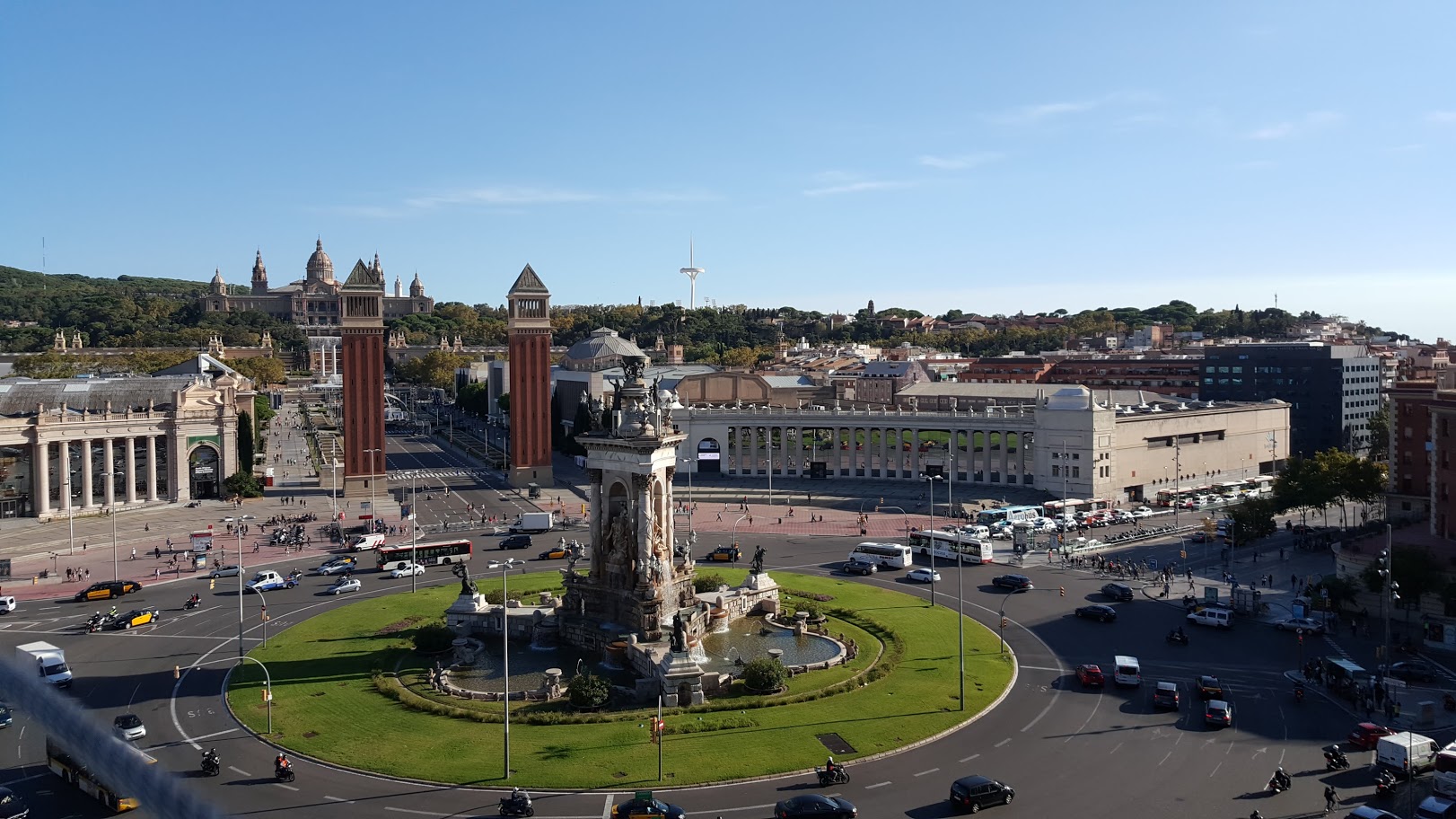 About Barcelona 1 Spain square, Plaça Espanya with a fountain and two Venetian towers, Barcelona. Montjuic at the background.