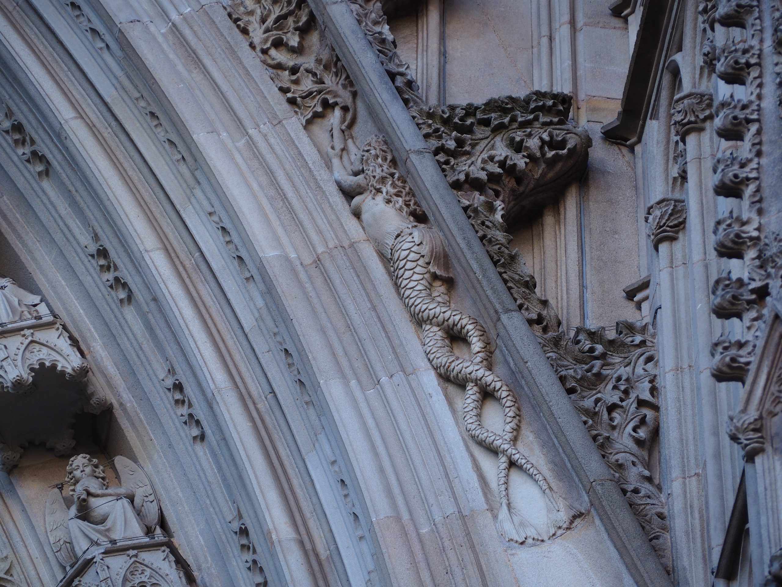 escultura de sirena con dos colas en la fachada de la catedral de Barcelona durante la busqueda del tesoro del barrio gótico