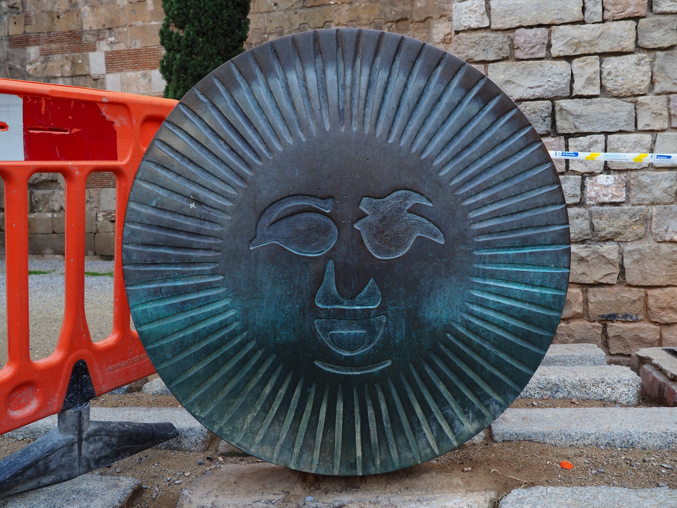 A sun sculpture on iron, the O letter on the Barcino sculpture. Barcelona treasure hunt. Gothic quarter.