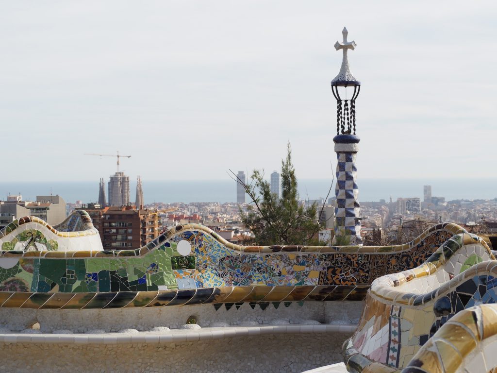Park Güell undulating bench with ceramic mosaics an Barcelona views at the background. Antoni Gaudí