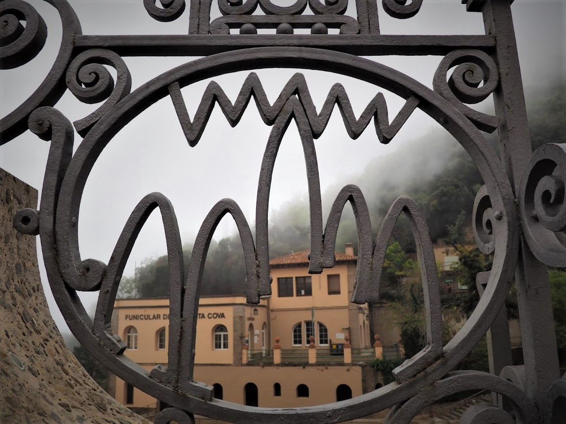 La valla con el símbolo de Montserrat y la estación del Funicular al fondo