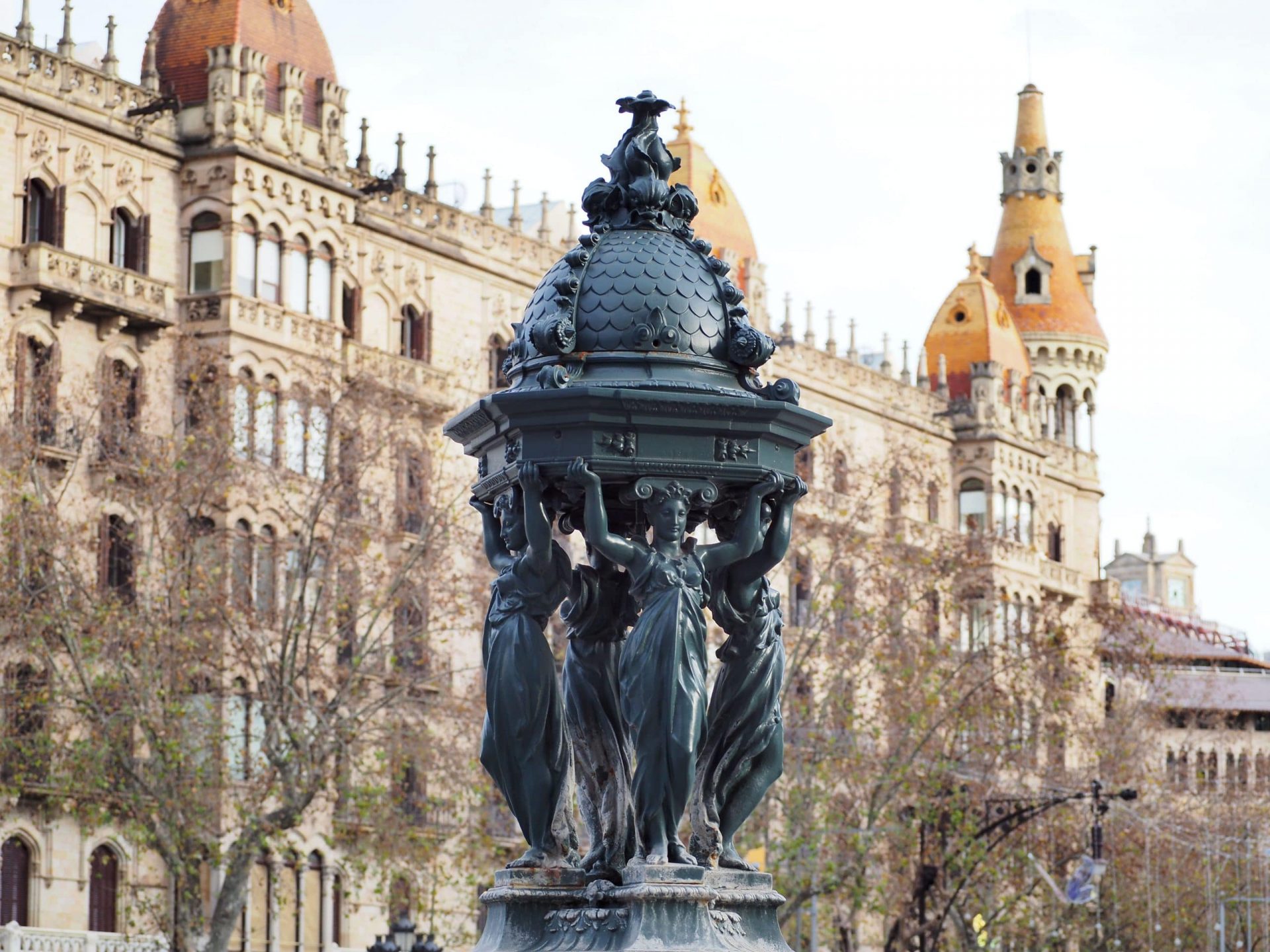 Fontaine Art nouveau avec un bâtiment moderniste en arrière-plan. Barcelone.